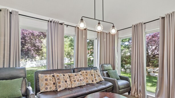 A living room with a leather sofa, a round coffee table, and a book. - Grand Mountain Retreat: Hot Tub, Sleeps 21, Sofa Sleeper on Main Floor (Draper)