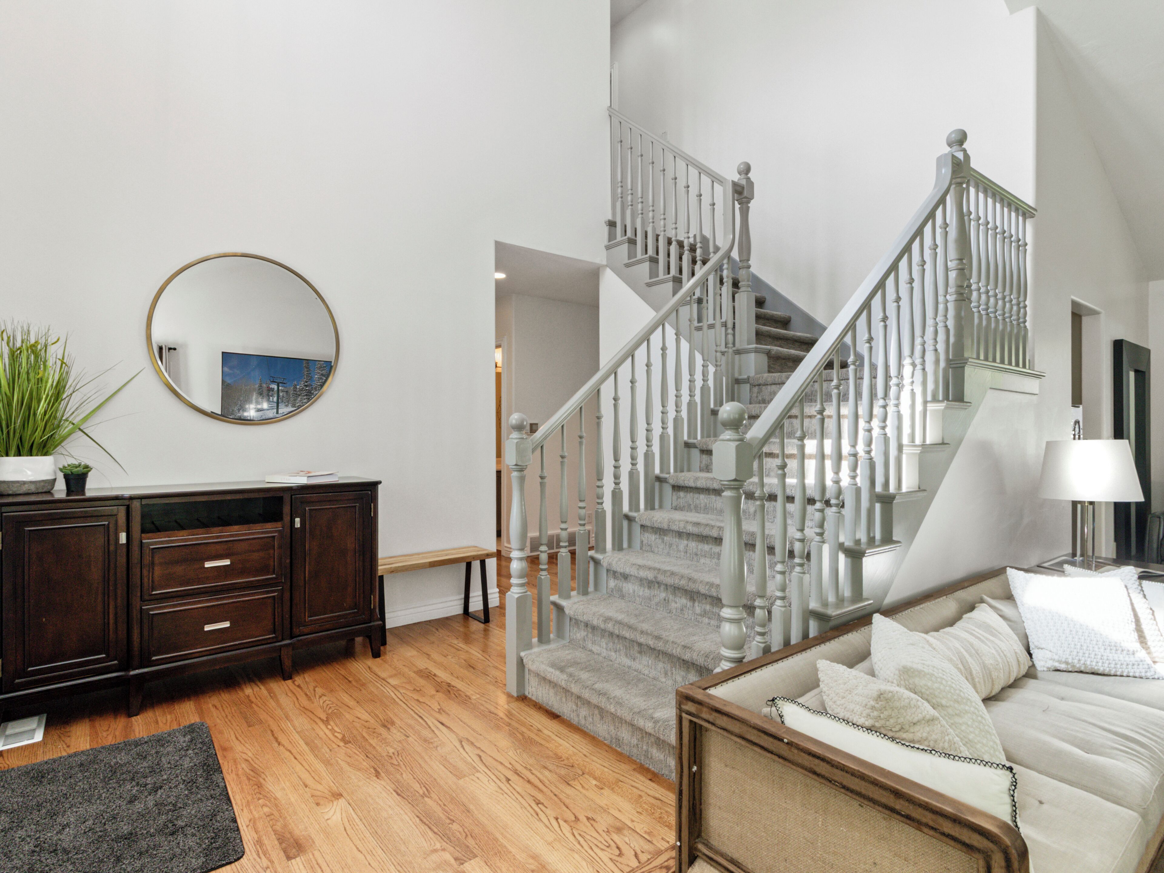 Welcoming main floor entryway with grand staircase. Hardwood floors throughout main floor.