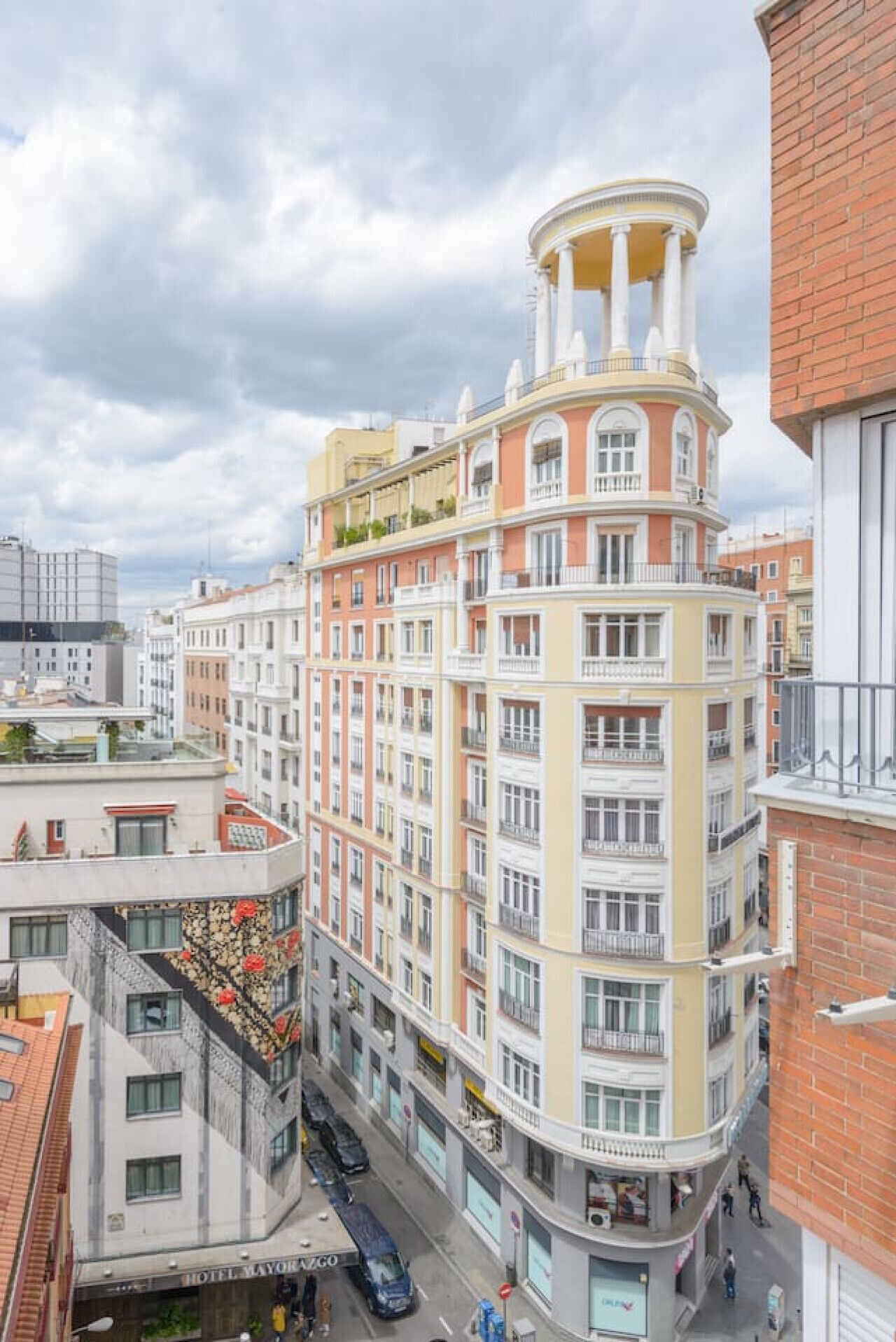 Un hotel de varios pisos con fachada curva, balcones y una torre central.