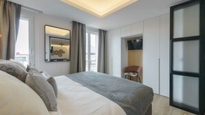 Une chambre d’hôtel moderne dotée d’un grand lit, d’une télévision à écran plat, d’un bureau et d’une grande fenêtre.