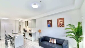A modern apartment with a kitchen, dining area, and living room. - Downtown Condo near Vancouver Skytrain (Surrey)