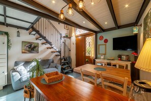 A modern living room with a staircase, wooden dining table, and a TV mounted on the wall. - Casa Azul - Welcome To Rhome (Rome)