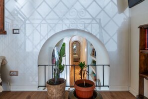 A room with a large arched doorway, a cactus plant, and a potted plant. - Casa Azul - Welcome To Rhome (Rome)