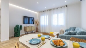 Un salon moderne comprenant un coin repas, un canapé et un téléviseur.