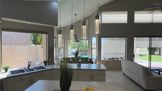 A modern kitchen with a central island, pendant lighting, and large windows. - Wonderful 5-bedroom house in welcoming Gilbert (Gilbert)