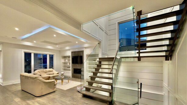Un salon moderne avec un escalier, un canapé et une cheminée.