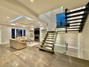A modern living room with a staircase, a sofa, and a fireplace. - A Unique Getaway Awaits You! (Toronto)