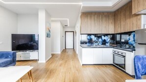 Una cocina moderna con armarios de madera, horno empotrado y un ventanal grande.