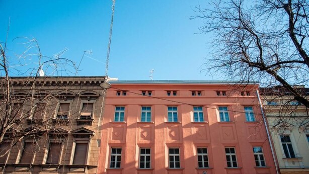 Een meerhoog gebouw met een roze gevel en een klassieke bouwstijl.