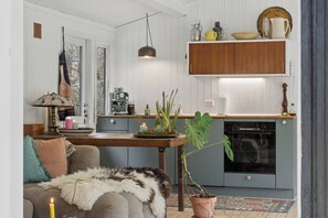 A cozy living room with a sofa, a coffee table, and a fireplace. - Holiday home with fire pit and space to play (Højby)