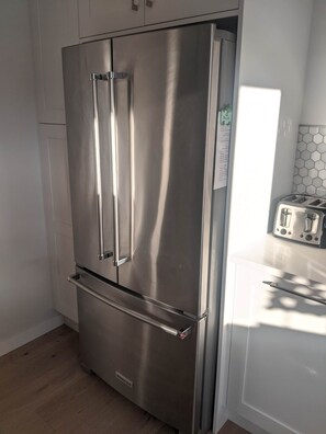 A stainless steel refrigerator with a lower freezer compartment, a built-in ice maker, and a water dispenser. - Churchill Beach House (Penticton)