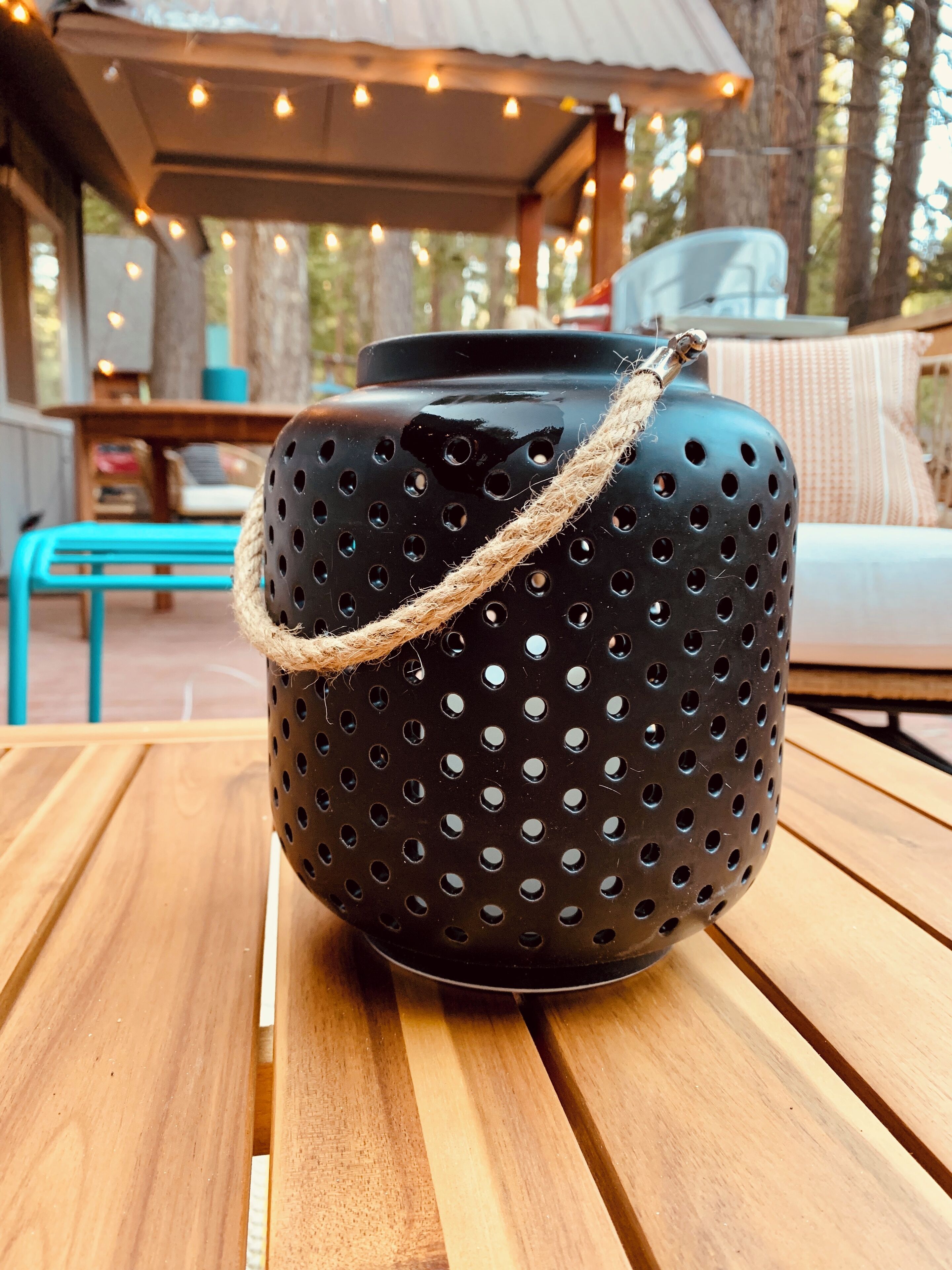 A black pot with a rope handle on a wooden table.
