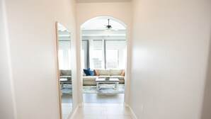 Ein Flur, der in ein Wohnzimmer mit Sofa und Couchtisch führt.