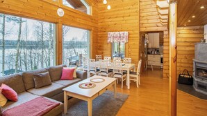 Interior acogedor de una cabaña con detalles de madera, un comedor y una chimenea.