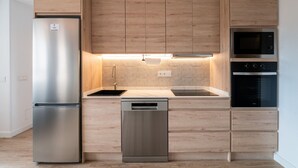 Una cucina moderna con mobili in legno, elettrodomestici in acciaio inossidabile e lavastoviglie.