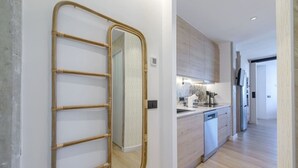 A modern kitchen with a built-in dishwasher, a stainless steel sink, and a microwave. - GRAN VIA capitals,ISLAS MAURICiO (Madrid)