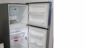 Ein offener Kühlschrank mit mehreren Regalen und einer Bedienblende.