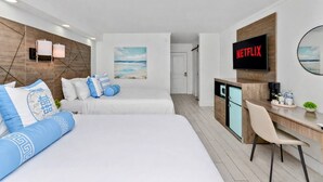 A modern hotel room with two beds, a desk, a TV, and a view of the beach. - Bright & Modern Studio • 2 Queen Beds • 3-Min Walk to Beach (Myrtle Beach)