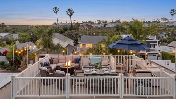 A rooftop patio with outdoor furniture, a fire pit, and string lights. - Designer Beach Home, Rooftop Deck, Free Parking, Bike Rentals, King Suites (Newport Beach)