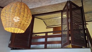 Un intérieur traditionnel agrémenté d’un luminaire en fibres tressées, de panneaux coulissants en bois de style shoji et d’un escalier.