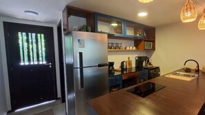 Une cuisine moderne dotée d’un réfrigérateur en acier inoxydable, d’un four encastré et d’une table à manger en bois.