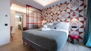 Quarto moderno com uma cama grande, parede com padrão vermelho e branco, e um claraboia.