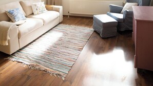 Una sala de estar con sofá, sillón, reposapiés y un ventilador de techo.