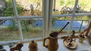 A window with a view of a rocky landscape and a body of water.
