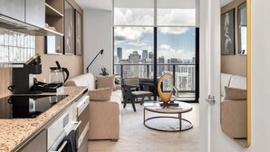 Eine moderne Wohnung mit Küche, Wohnbereich und großen Fenstern mit Stadtblick.