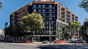 A multi-story building with a modern architectural design, featuring balconies and large windows. - Escape to Skyline Views & Rooftop Pool Bliss (Mexico City)