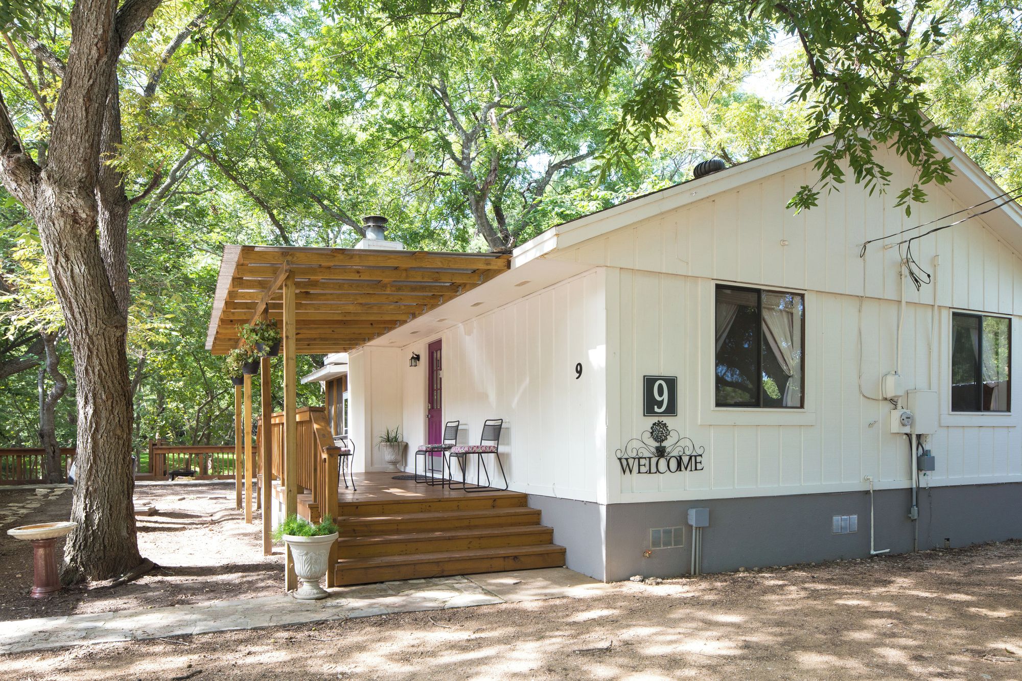 A single-story building with a porch, a welcome sign, and a number '9' on the wall.
