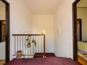 A staircase with a railing, a small table with a candle, and a wall-mounted light fixture. - CIRO CH / HR-07098-04 by Interhome (Selce)