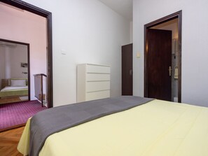 A bedroom with a bed, a dresser, and a door leading to another room. - CIRO CH / HR-07098-04 by Interhome (Selce)