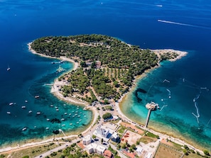 An aerial view of a coastal town with clear blue waters, a small island with dense greenery, and a few buildings near the shore. - Casetta Marija by Interhome (Pula)