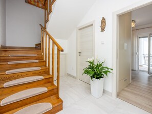Eine Holztreppe mit einer weißen Wand und einer Tür zu einem Balkon.