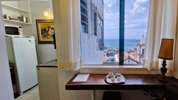 Een keuken met uitzicht op de zee, een tafel met een lamp en een klein beeldje.