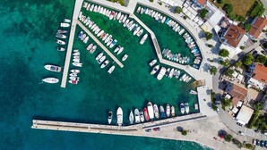 An aerial view of a marina with numerous boats docked, surrounded by residential buildings and a clear waterfront. - Apartment Belavic - 2 by Interhome (Krk/Njivice)