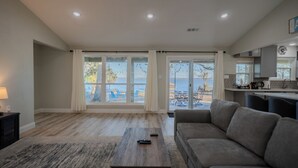 Un salon spacieux avec une grande fenêtre, un canapé et une table basse.