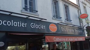 Une devanture de magasin avec des enseignes indiquant « Poulichette » et « Boulangerie Pâtisserie ».