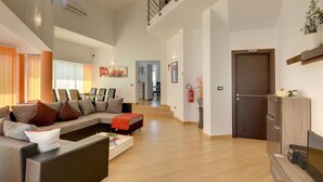 A spacious living area with a sofa, a coffee table, and a TV stand. - Villa Marcelia by Interhome (Bokordici)
