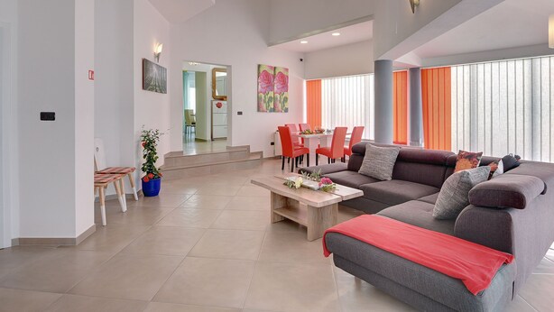 A modern living room with a sofa, coffee table, and dining area. - Villa Marcelia by Interhome (Bokordici)
