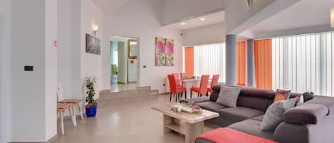A modern living room with a sofa, coffee table, and dining area.