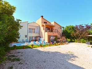 Ein Gebäude mit Schwimmbad, Außenbereich und Kiesfläche.