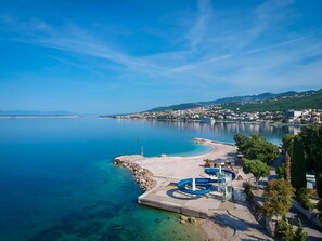 A coastal town with a clear blue sea, a sandy beach, and a small pier. - MALI MARINO 1 / HR-09058-01 by Interhome (Selce)