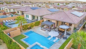 A residential area with multiple houses, a swimming pool, and outdoor seating areas. - Golf n Grooves. Luxury La Quinta Villa. (La Quinta)
