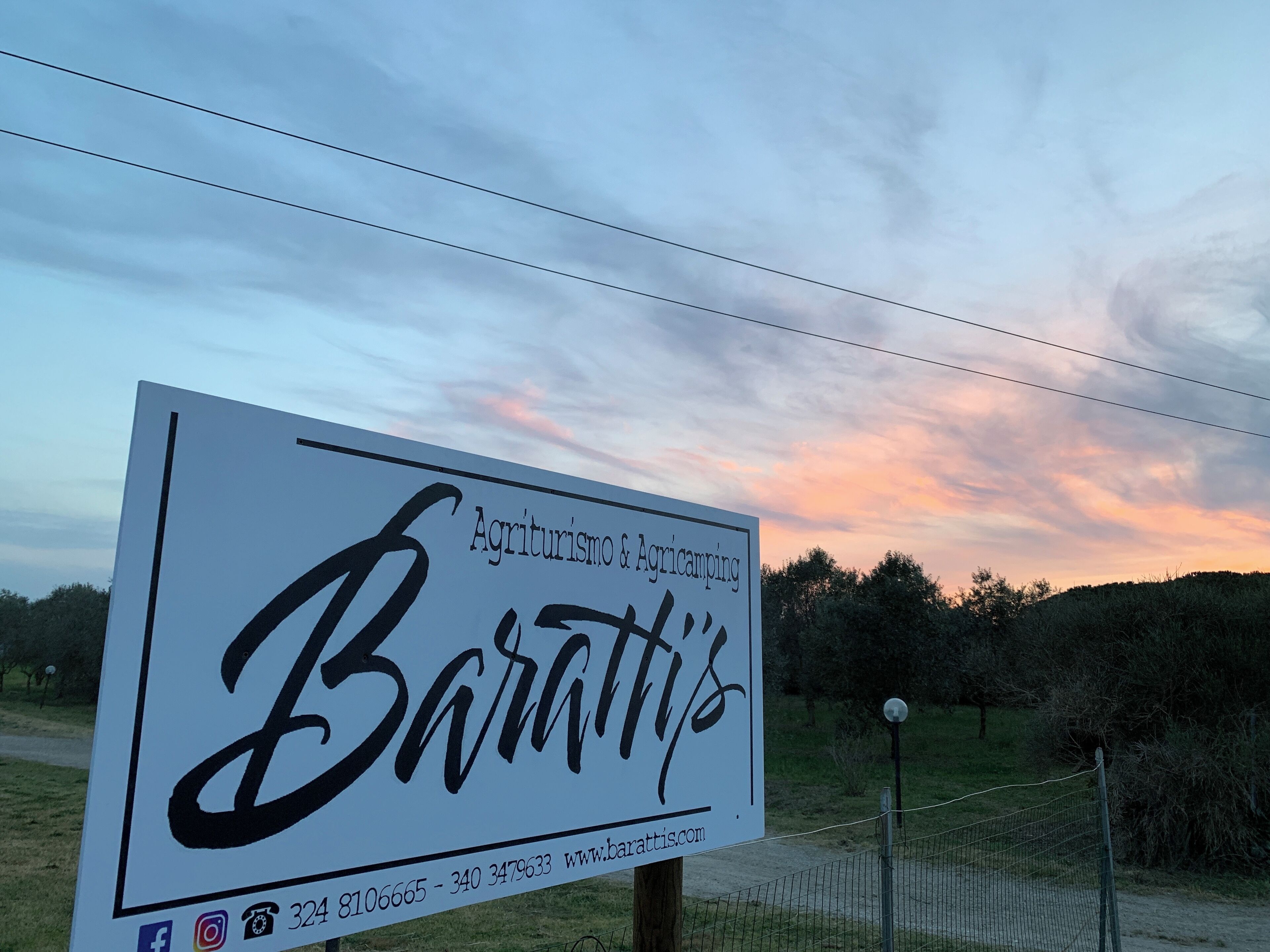 A sign for 'Baratti's' with contact information and social media icons.