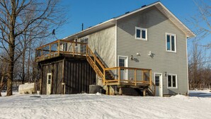 A two-story house with a wooden deck and a large garage. - The Bognor House (Meaford)