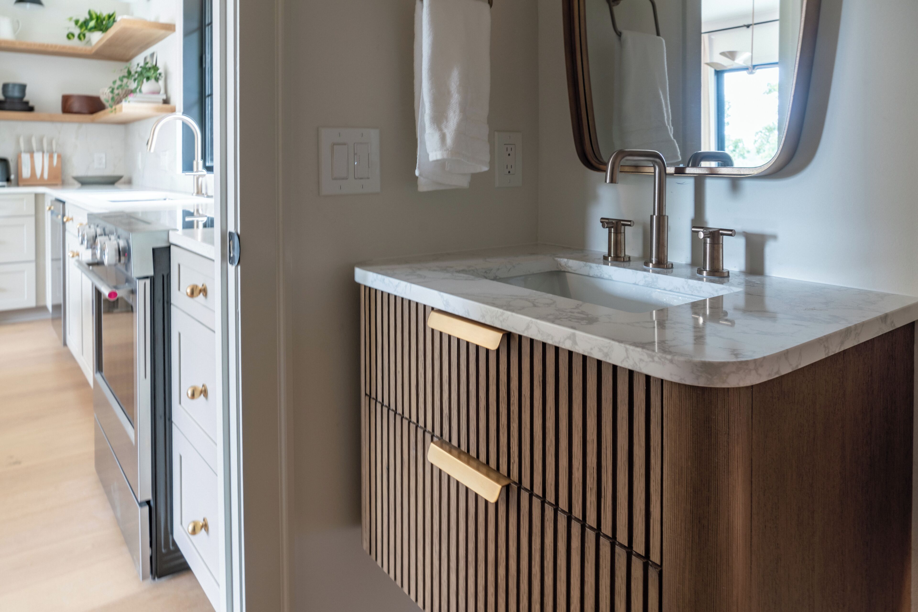 A modern kitchen with a built-in sink, wooden cabinetry, and a stainless steel range hood.