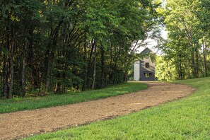 A gravel path leading to a stone building surrounded by dense trees. - NEW - Private Hilltop Retreat • Hot Tub • Stunning Views • King Suite (Columbia)