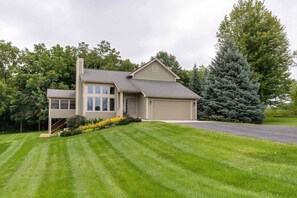 A two-story house with a garage, a covered porch, and a well-maintained lawn. - Beautiful Peaceful Galena Home. Hot Tub, Sunroom, Pool Table, Arcade  4BR, 3.5BA (Galena)